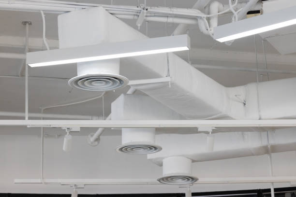 A white ceiling with a series of vents and lights